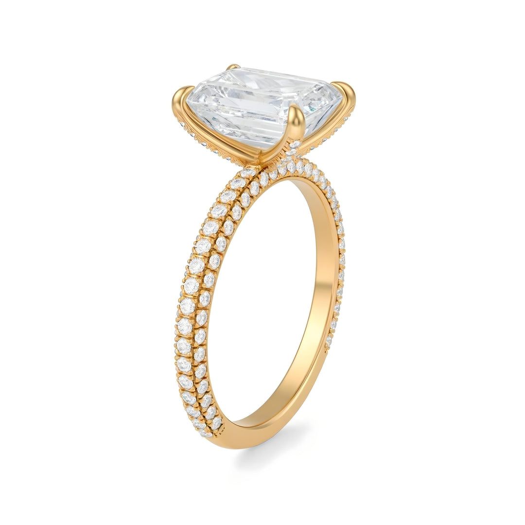 Gold ring with a large diamond and smaller diamonds on the band against a white background