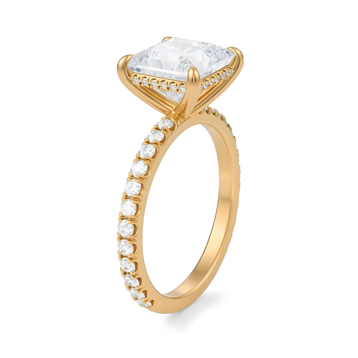 Gold ring with a large diamond and smaller diamonds on the band against a white background