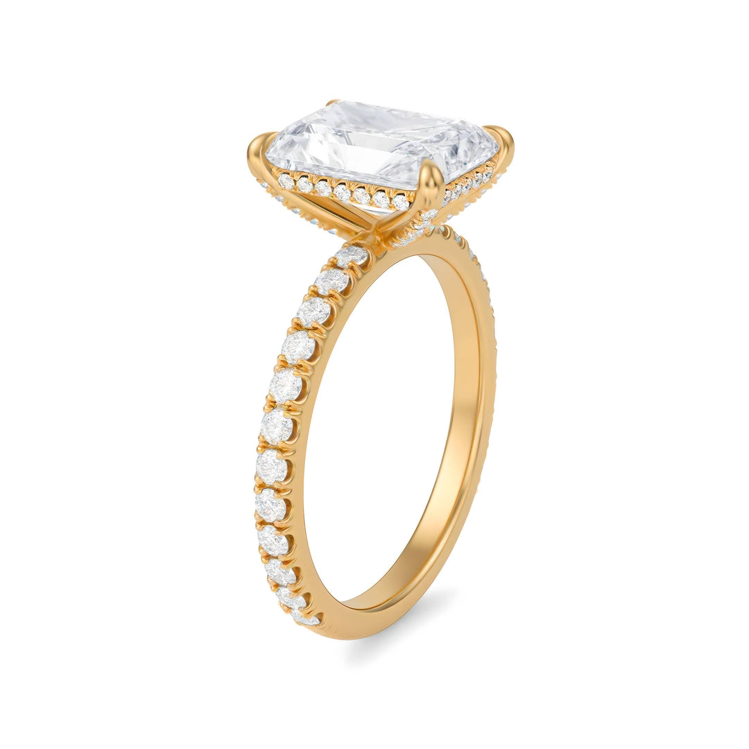 Gold ring with a large diamond and smaller diamonds on the band against a white background