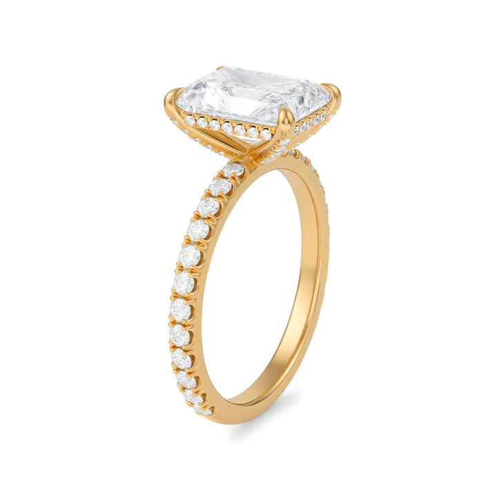 Gold ring with a large diamond and smaller diamonds on the band against a white background