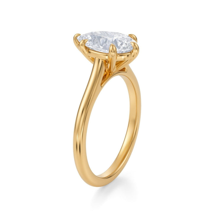 A silver ring featuring a pear-shaped diamond in a classic cathedral setting