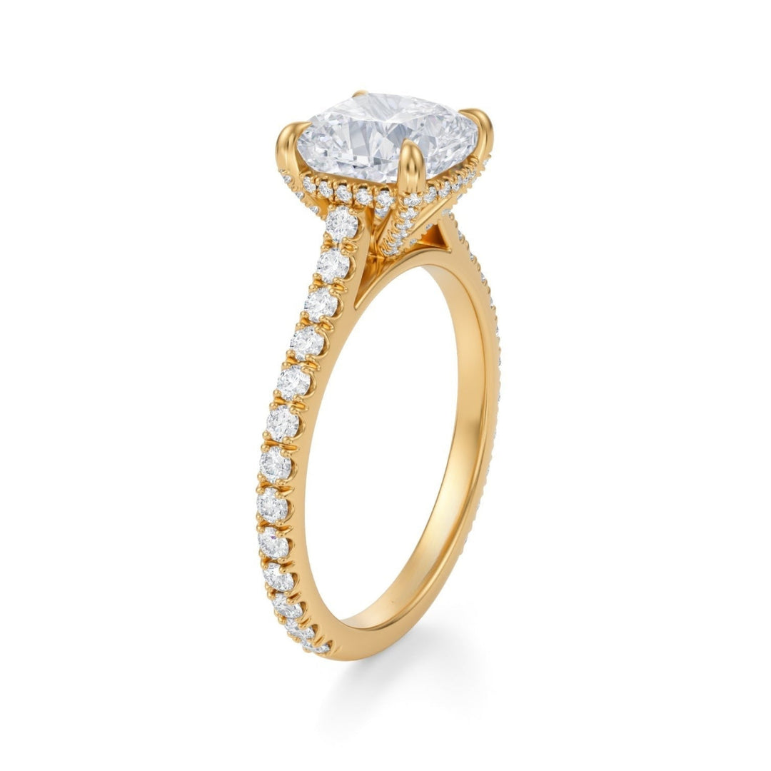 A cushion cut diamond ring with pave setting on a white gold band, displayed against a white background.