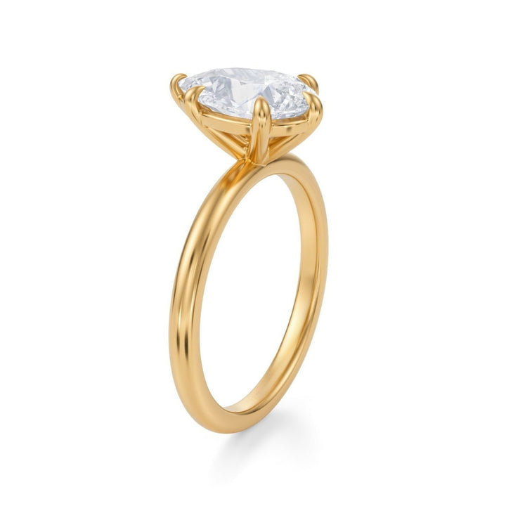 A silver ring featuring a pear-shaped diamond in a solitaire setting with a minimalist design.