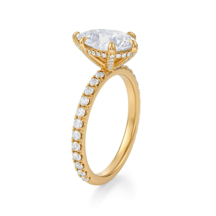 A Pear-shaped diamond ring with a pave band, set in a basket, against a white background.