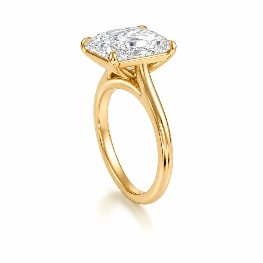 Side profile of an elongated cushion diamond solitaire ring in yellow gold with a cathedral setting on a white background.