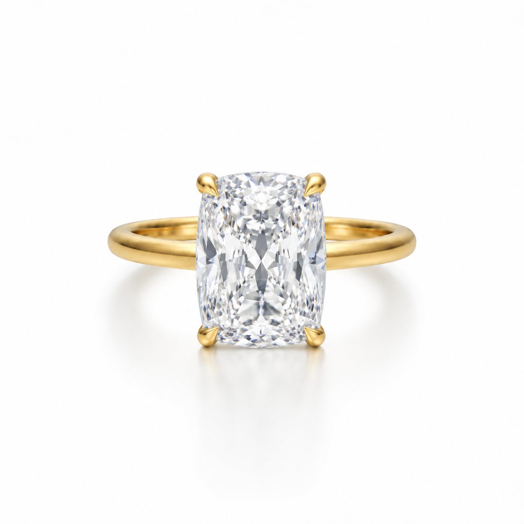 Elongated cushion-cut diamond solitaire ring in yellow gold with four-prong setting, shown from the front on a white background.