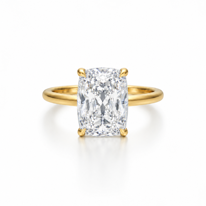 Elongated cushion-cut diamond solitaire ring in yellow gold with four-prong setting, shown from the front on a white background.