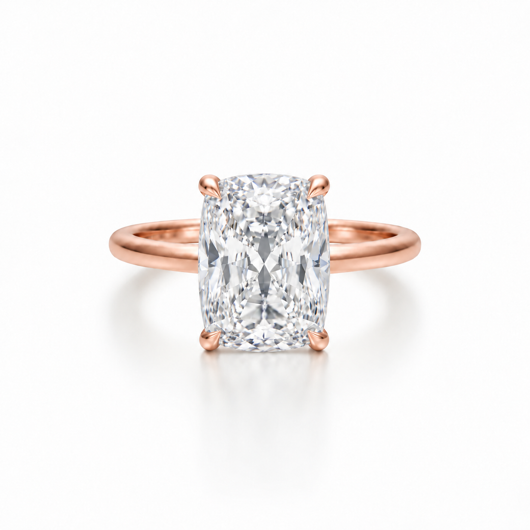 Front view of an elongated cushion diamond solitaire ring in a rose gold cathedral setting with four-prong claw detail.