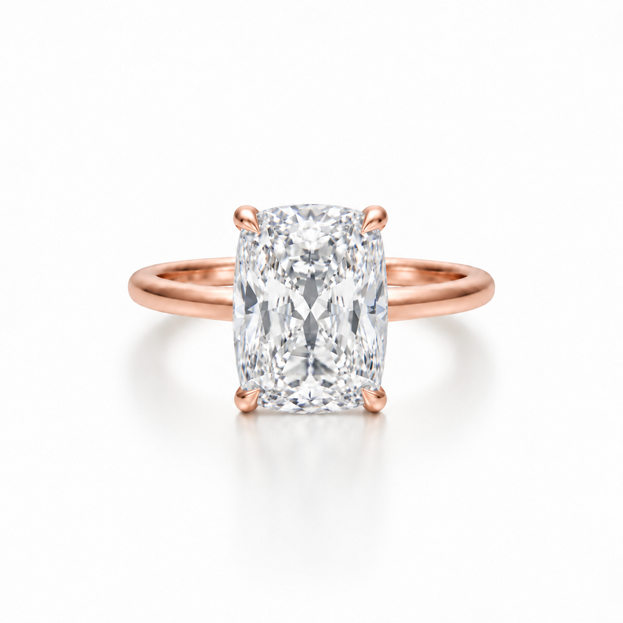 Front view of an elongated cushion diamond solitaire ring in a rose gold cathedral setting with four-prong claw detail.