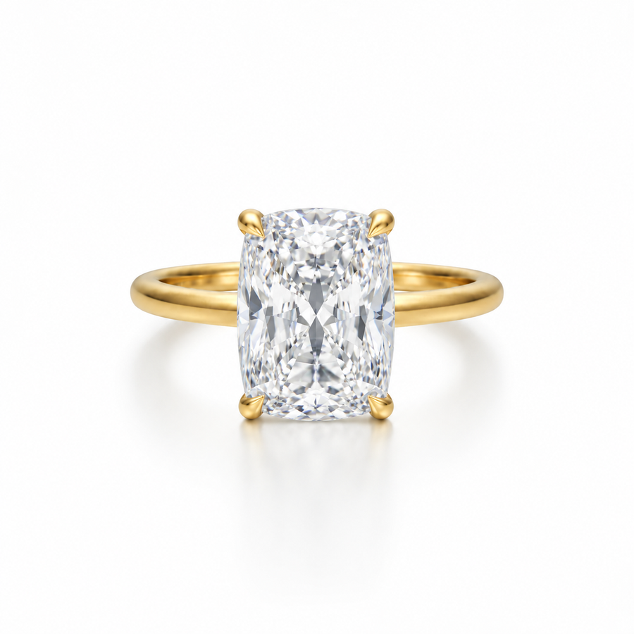 Elongated cushion-cut diamond solitaire ring in yellow gold with four-prong setting, shown from the front on a white background.