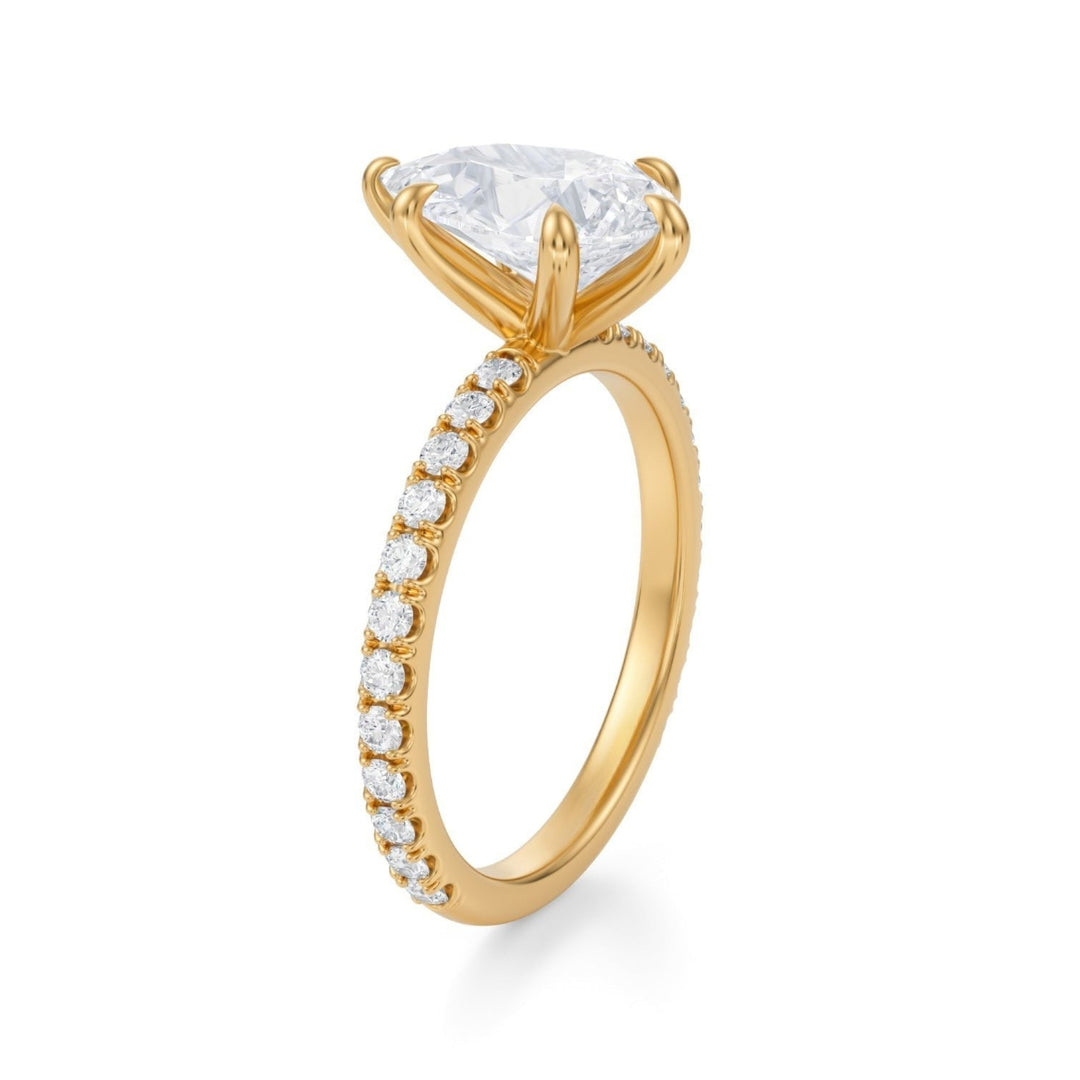 A silver ring with a pear-shaped lab-grown diamond centerpiece set in a pave band