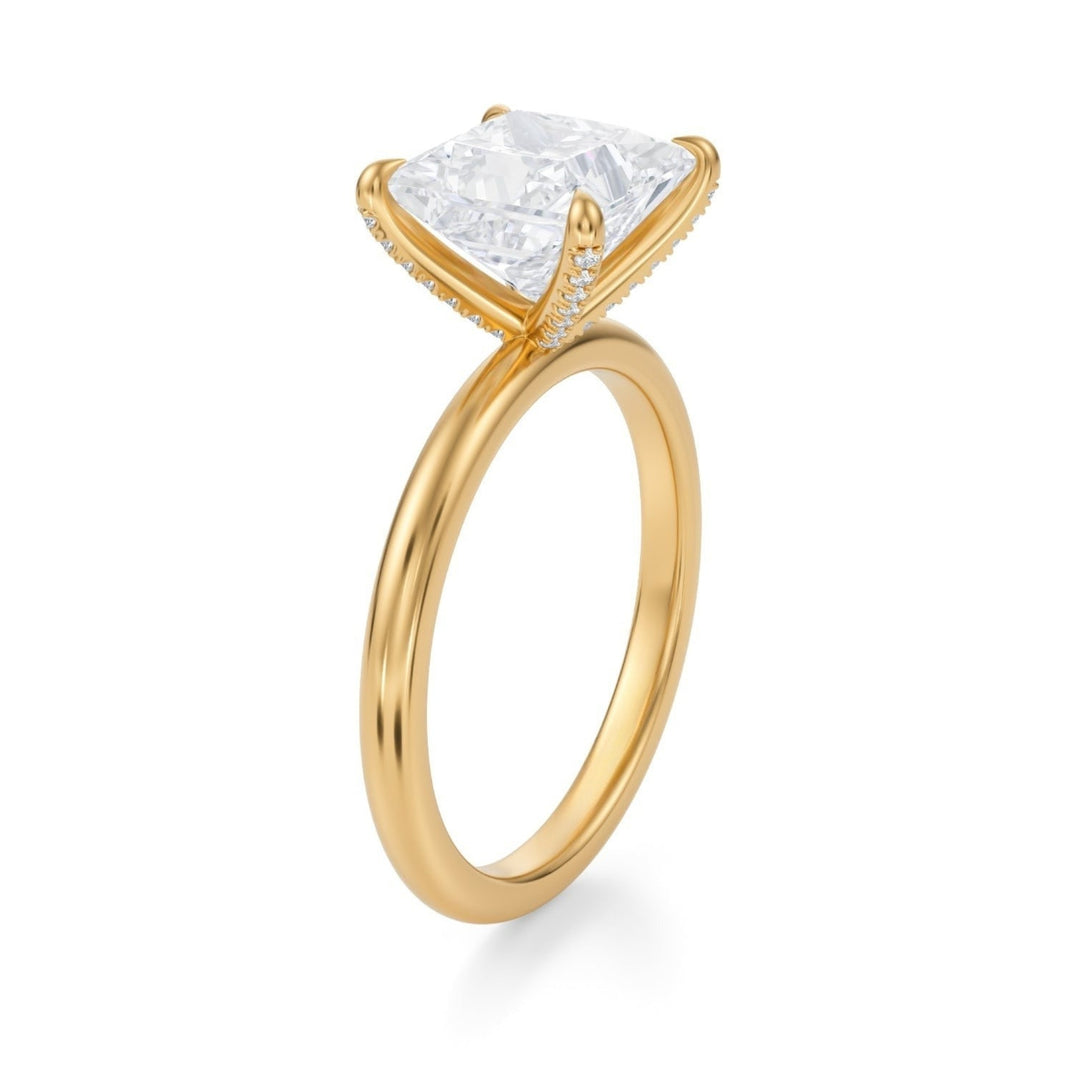 Gold ring with a large diamond and smaller diamonds on the band against a white background